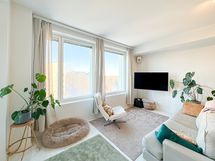 Asunnon olohuone kylpee luonnonvalossa.