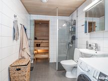 Kylpyhuone toimii käytännöllisesti myös kodinhoitotilana.