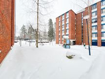 Talon päädyssä on lasten leikkitelineitä.