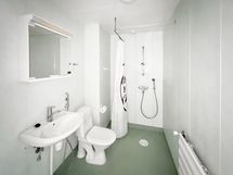 Tilava kylpyhuone, jossa wc, suihku ja paikka sekä liitännät pesutornille.