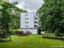 Oman tontin vehreää pihapiiriä, puutarhakalusteilla
