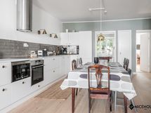 Avokeittiö ja ruokailutila olohuoneen suunnasta.