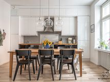 Keittiö ja ruokailutila samassa valossa kylpevässä huoneessa.