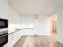 Tyylikkäässä keittiössä on integroidut kodinkoneet ja runsaasti tilaa kotikokin käyttöön.