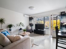 Olohuoneessa ilmalämpöpumppu. Asunnon olohuoneestä käynti katetulle terassille.