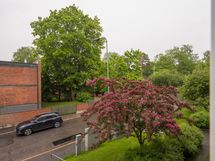 Näkymä kadun puolelle. Asunto sijaitsee toisessa asuinrivissä mereen nähden.