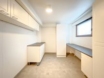 Iso kodinhoitohuone tarjoaa hyvät puitteet pyykkihuollolle.