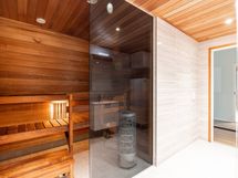 Sauna on lämpökäsiteltyä haapaa ja saunaseinän sävy on pronssi.