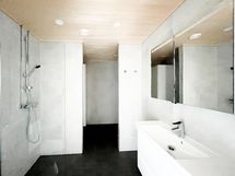 Kylpyhuone on tilava, ja pesukoneen ja pienen kodinhoitohuoneen omaisen tilan saa seinäkkeen taakse.