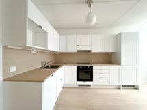 Tilava ja valoisa kolmio lasitetulla parvekkeella.