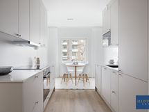 Keittiön päätyyn istuu hyvin ruokaryhmä.