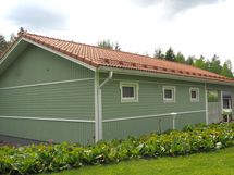 Talousrakennuksen nurkalta sähköputki vajalle