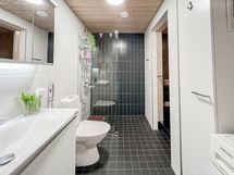 Tyylikäs, tilava ja saunallinen kylpyhuone, jossa pesukone.