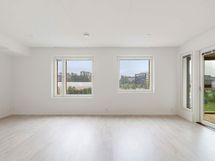 Valokuva asunnosta B 37 - olohuone, josta kulku lasitetulle parvekkeelle.