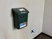 Kuva käytävältä. Kerhotilan postiluukku.
