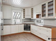 Kodikas vaaleasävyinen keittiö.