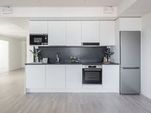 Näyttävä keittiö kivitasolla ja Boschin kodinkoneilla.