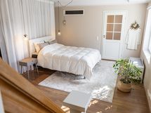 Alakertaan menevien portaiden päästä aukeaa levollinen näkymä makuuhuoneeseen.