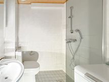 Laatoitetussa kylpyhuoneessa on valmiina pesukone.