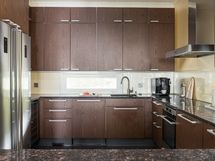 Tyylikäs Puustellin keittiö järeällä kivitasolla