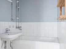 Kylpyhuone on remontoitavassa kunnossa. Kylpyhuoneen takana seinän toisella puolella on vaatehuone.