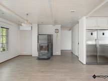 Olohuoneessa on varaava takka ja ilmalämpöpumpun sisäyksikkö.