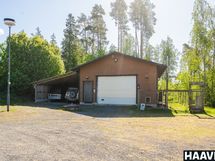 Iso, lämmin autotalli, jonka yhteydessä autokatos