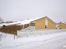 Suojainen päätyhuoneisto. Kesällä tiivis vihreä pensasaita antaa näkösuojan,