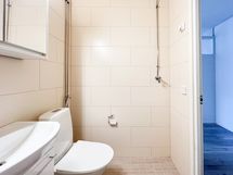 Kylpyhuoneeseen mahtuu päältä täytettävä pesukone.