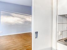 Keittiön ja huoneen välissä on liukuovi.