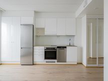 Keittiössä on astianpesukone, induktioliesi ja täysikokoinen jääkaappi-pakastin.