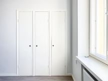 Säilytystilana kaapit, josta löytyy hyllyt sekä vaatetanko.