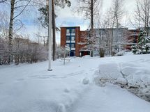 Pihalla on lasten leikkitelineitä ja istuinryhmä sekä mattotelineet.