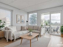 Valoisa olohuone, josta käynti lasitetulle parvekkeelle