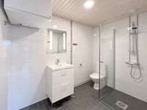 Tyylikäs kylpyhuone on iso ja siellä on tilaa myös pesutornille.