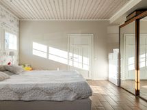 Alakerran makuuhuone, jossa kuituvalot katossa. Käynti huoneen omaan kylpyhuoneeseen