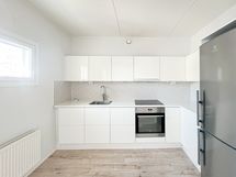 Keittiö on kauniin vaalea asettuu käytännöllisesti olohuoneen yhteyteen.