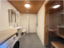 Tilavaan ja lattialämmityksellä varustettuun kylpyhuoneeseen mahtuu hyvin pesukone.