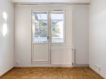 Yläkerran päämakuuhuone jossa on seinän verran liukuovikaappeja ja käynti parvekkeelle.