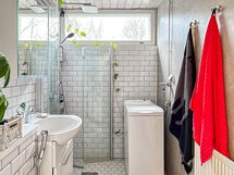 Kylpyhuone on upeasti laatoitettu ja iso ikkuna antaa tilaan valoa.