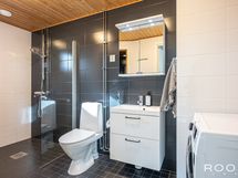 Kylpyhuone/WC-tilassa on moderni varustelu ja tilaa perheen pyykkihuollolle.