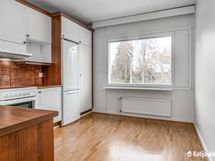 Valoisa keittiö , jossa runsaasti kaappitilaa.