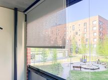 Parvekkeella koko lasituksen matkalta rullaverhot, jotka suojaa auringolta ja tuo yksityisyyttä.
