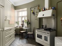 Viehättävä keittiö, jossa mm. kaasuliesi parilatasolla ja kaksi uunia.