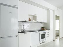 Vaalea keittiö sulautuu asunnon raikkaaseen värimaailmaan.