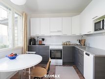 Tyylikäs keittiö, jossa on riittävästi kaappeja ja kokkaustilaa