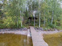 Laiturilta katsottuna alhaalla saunamökki ja mäen päällä päärakennus