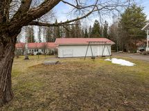 Yhtiön pihaa, varastorakennus ja keinut.